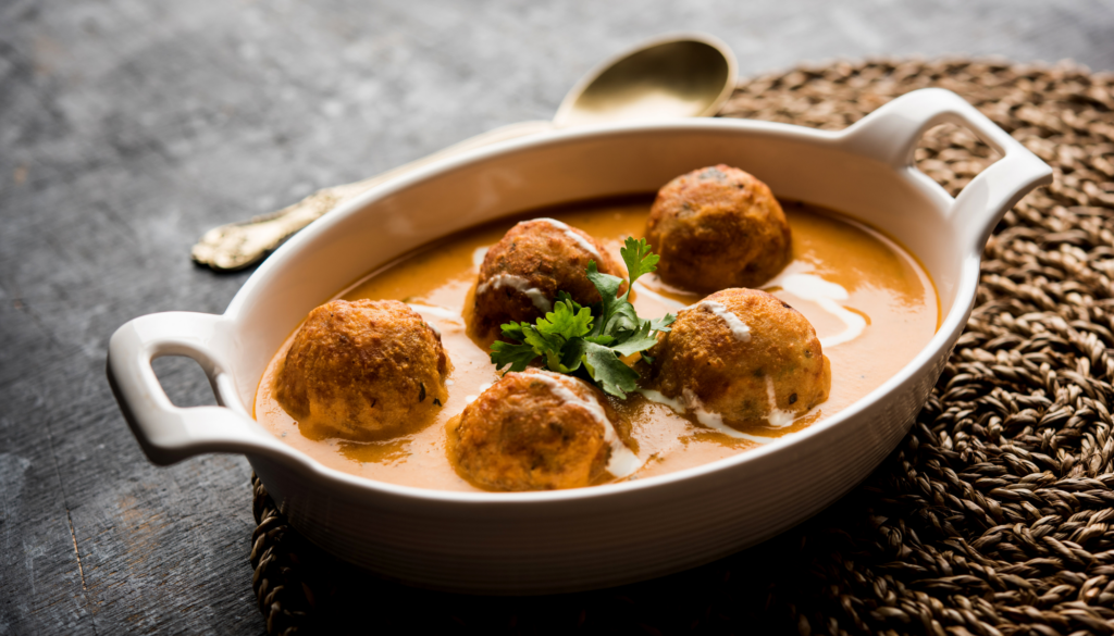 Soft dumplings made of mashed potatoes and paneer, simmered in a rich, creamy tomato and cashew-based gravy.